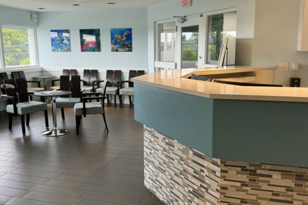 Interior view of the Freeman Orthodontics office reception area, showing the modern reception desk, seating area, and colorful artwork on the walls.